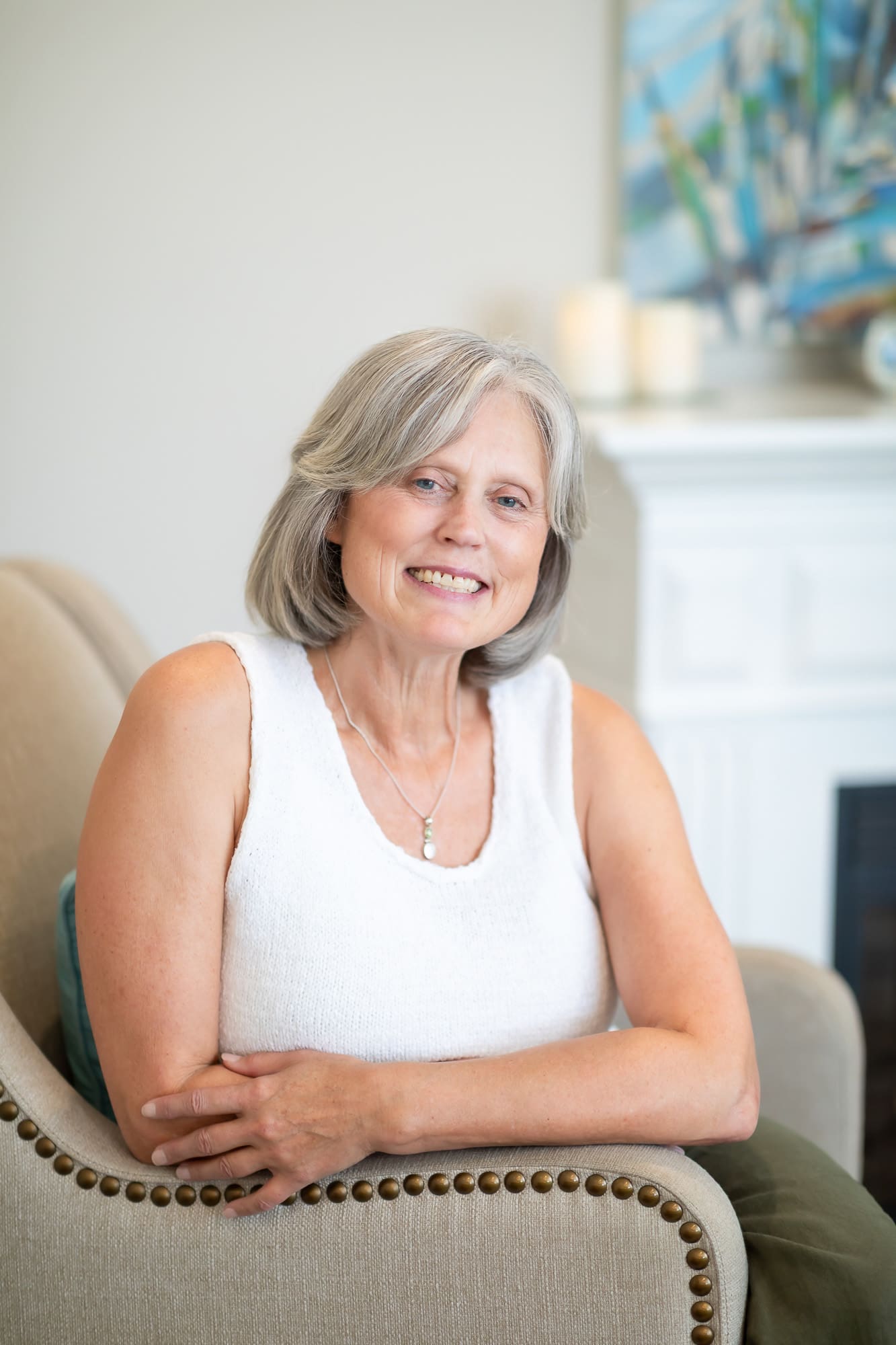 A woman sitting in a chair with her arms crossed, displaying a thoughtful expression.